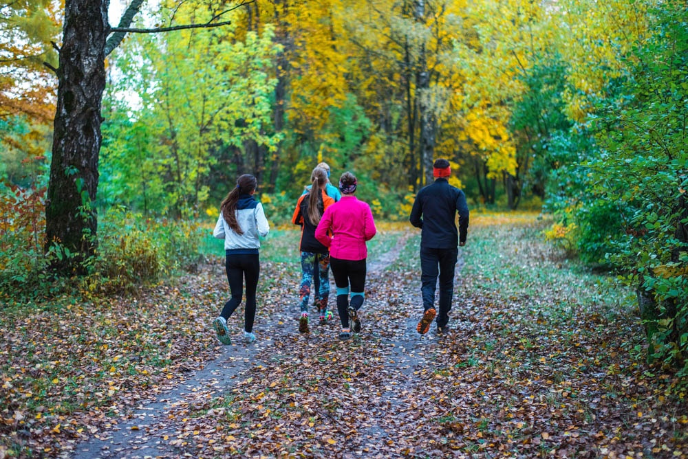 Running people. Adult athletes run along path park, an active way of life fall nature. Running athletes park run early morning. Several children are running woods doing sports. Healthy lifestyle.