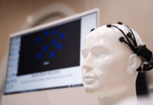 New Device for PTSD Being Sold to Veterans—No Evidence Provided to the Public Simulate wearing brain scanning waves, medical equipment In the laboratory with monitors showing reading and brain.