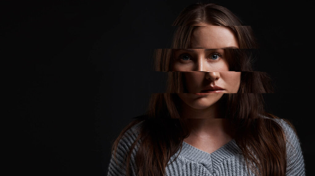 Studio shot of a woman posing against a dark background with a distorted face.