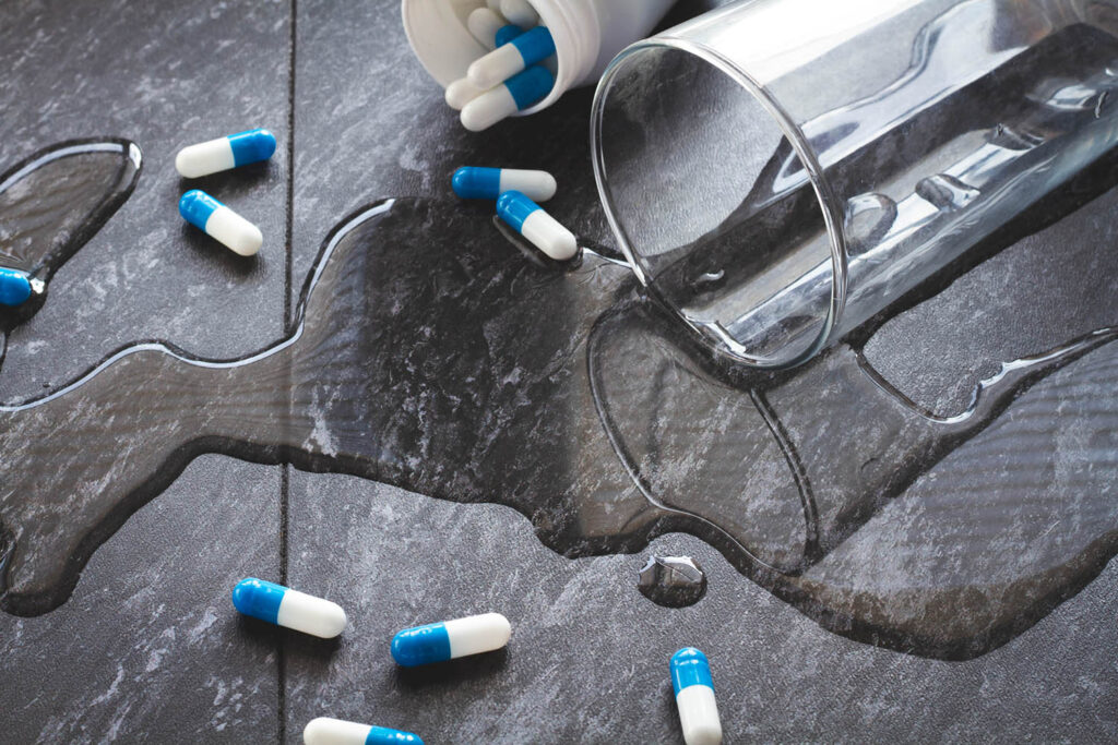 Water is spilled and medical capsules are scattered