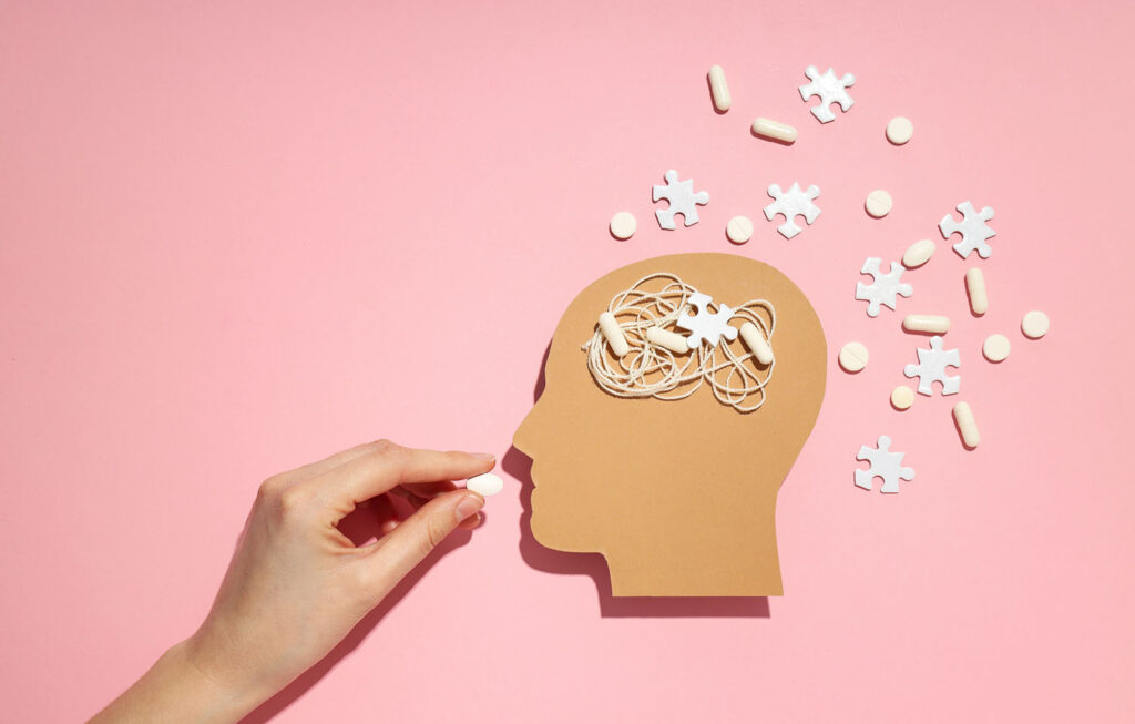 Illustration of hand feeding pill to head with puzzle pieces around it